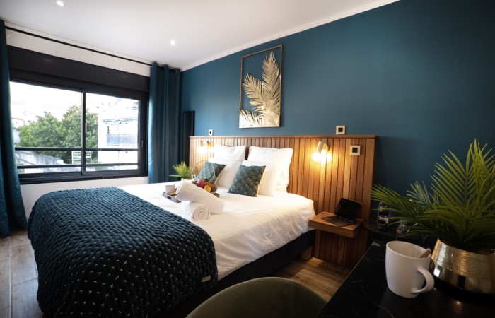 Chambre Palmier : Supérieure
Situé au 2e étage, votre chambre Palmier de 17m2, alliant confort, modernité et intimité saura vous séduire avec ses teintes de vert malachite, de doré et de bois. Dotée d’un lit king size, et d’une salle de bain avec douche italienne, elle vous offrira tout le confort souhaité pour une halte apaisante au cœur de Saint Denis.
En savoir plus
Reserver au meilleur prix